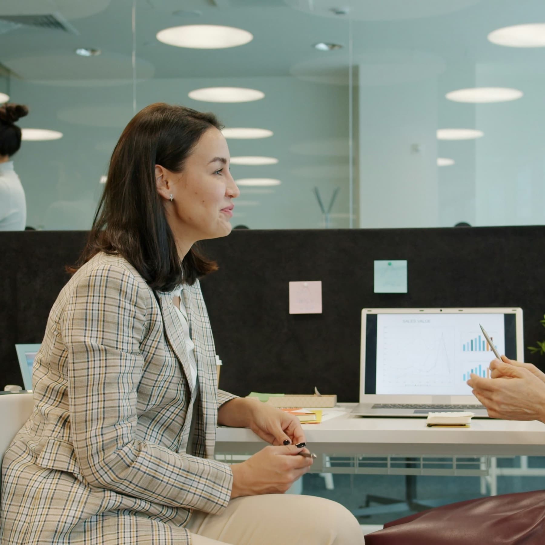 Two women in a meeting at a desk in a bright office