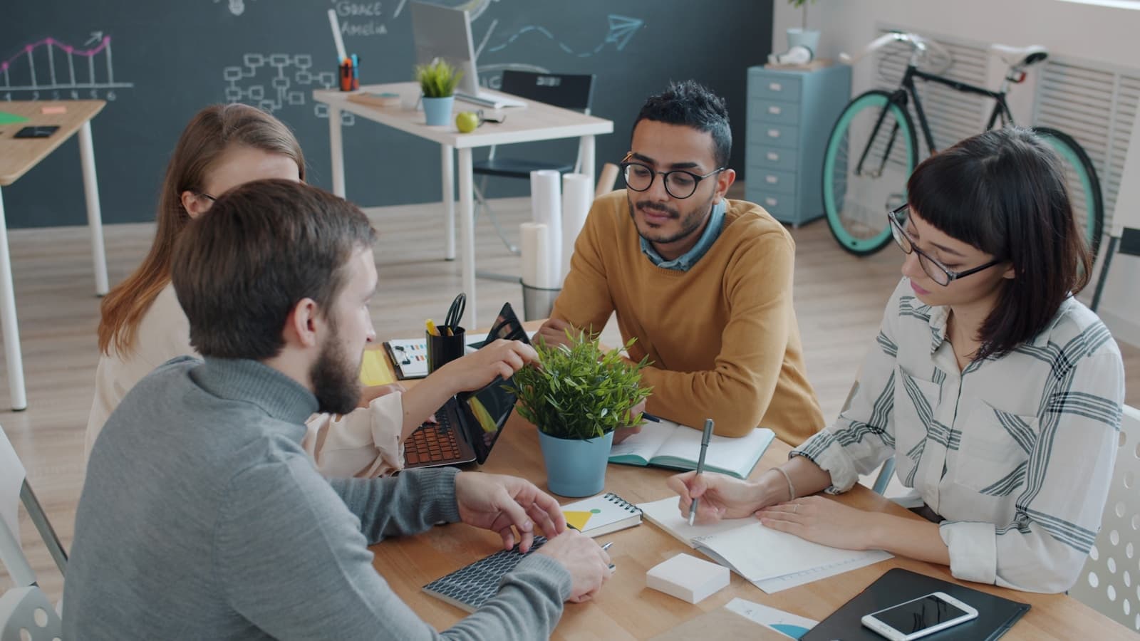 Diverse team talking around a table in a bright office